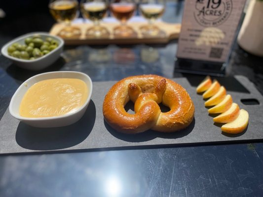 Cider cheese with a pretzel and sliced apples