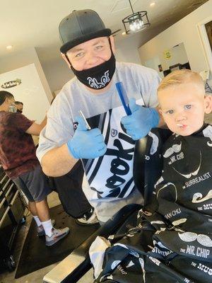 2 year old boy getting a fresh cut by Jeremy bridges with his Covid mask on