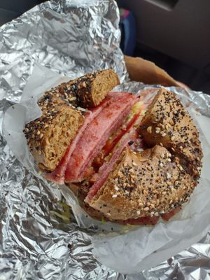 Everything pumpernickel bagel with Taylor ham/pork roll and tomato, shredded lettuce