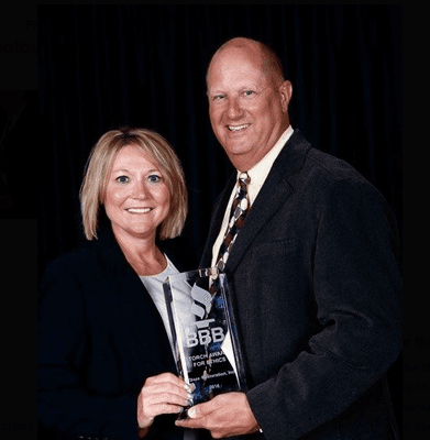 Michael and Danette Simons owners of Blaze Restoration holding the BBB Torch Award for Integrity and Business Ethics.