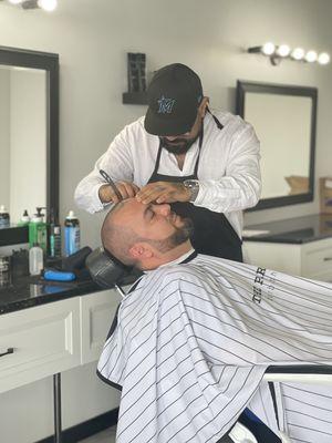 Barber Erick giving a shave