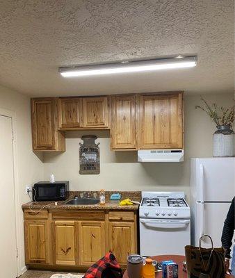 Newly updated kitchen area.  4-burner has stove, small microwave. Good size fridge.