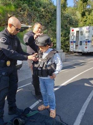 My grandson with 2 Officers putting a vest on him