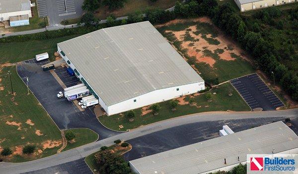 Building materials supplier Builders FirstSource's forklift is moving wood roof trusses.