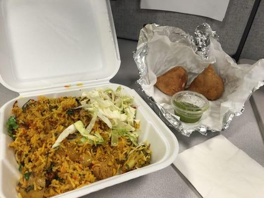 Veggie biryani and veggie samosa with mint sauce.