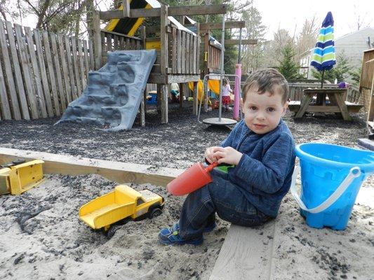 Sandbox time (climbing structure and slide in background)