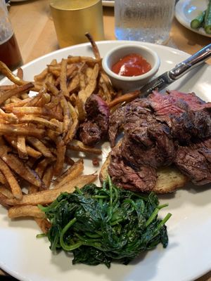 Hangar steak on garlic toast with sautéed spinach and house fries