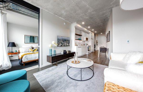 Staged, open concept living room with hardwood style flooring.