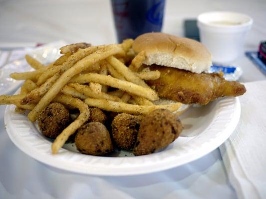 Fish sandwich, fries, and hush puppies