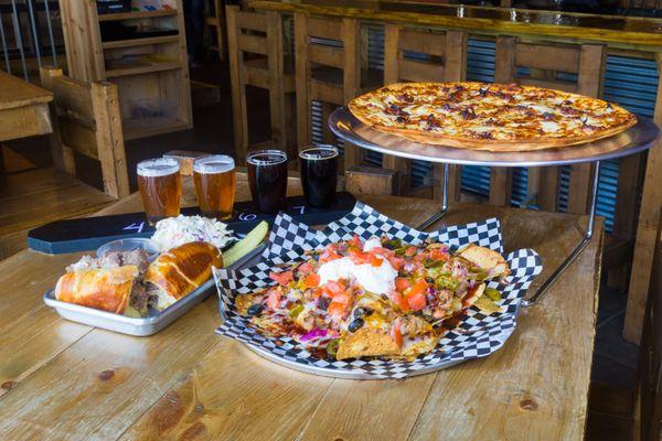 Beer flight, french dip sandwich, pulled pork nachos and chicken bacon ranch pizza