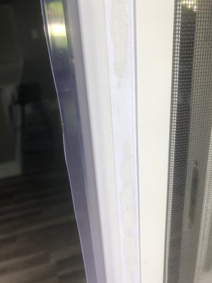 Plastic, unevenly cut, stuck on outside of sliding door.