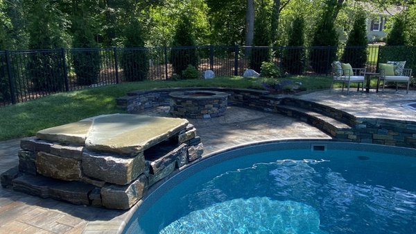 Waterfall and fire pit with a seatwall.