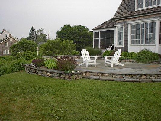 Bluestone patio with fieldstone retaining wall and step.