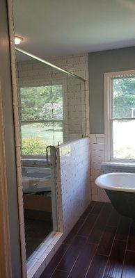 Custom shower glass enclosure with brushed nickle header and hardware installation.