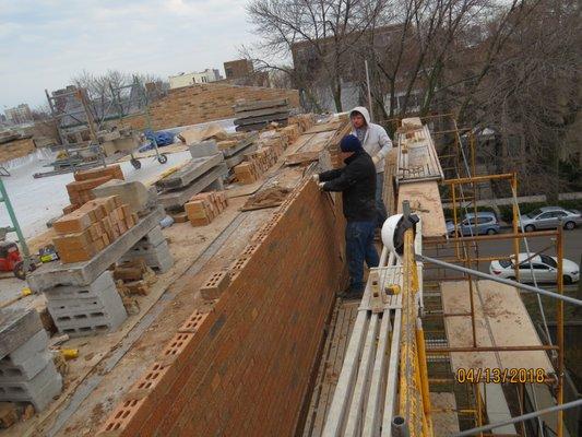 Brick masons. Parapet wall rebuilding.