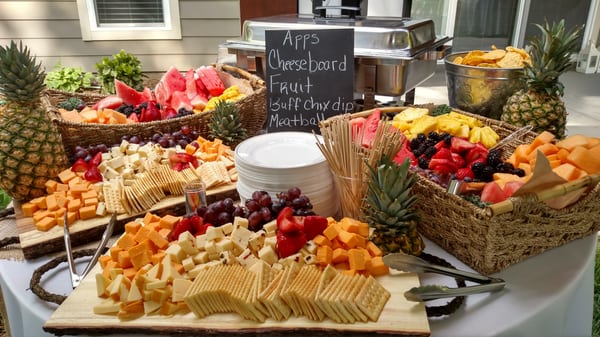 Appetizer station with cheese cubes, meatballs, fruit, buffalo chicken dip and chips