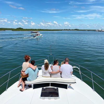 Family sitting together on bow of boat.