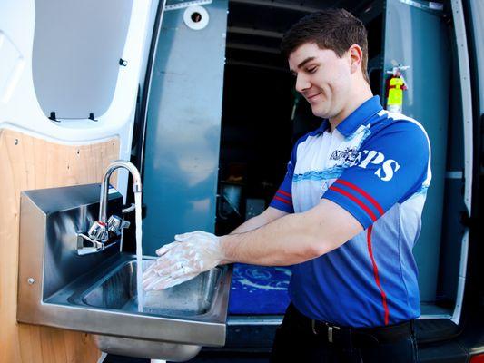 Express Plumbing technician washing his hands using his hand washing station.