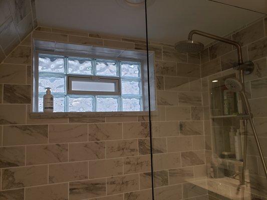 Glass block window installation with marble ledge and new tiled shower