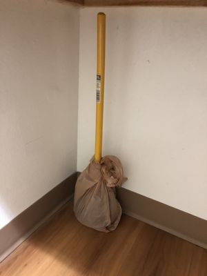 Plunger wrapped in plastic bag under sink.