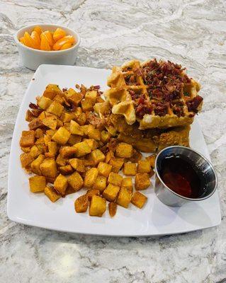 A fried chicken breast on top of sugar waffles topped with bacon bits and served with REAL maple syrup!!