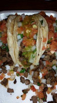 Tacos De Asada Simple ingredients But very Tasty steak cilantro onions tomatoes.