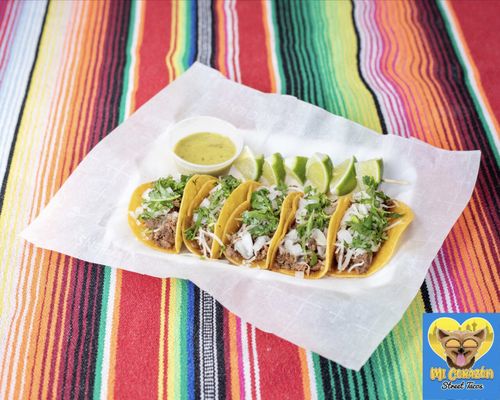 Beef Asada Street Tacos, topped with Monterrey Jack Cheese, onions, cilantro with limes and salsa verde on the side.