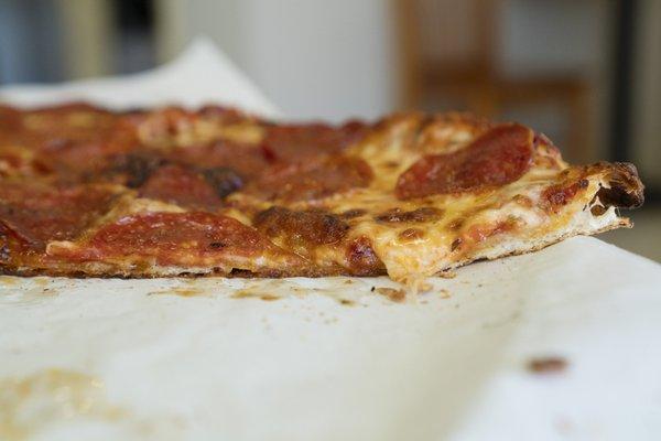 side shot of large pepperoni pie