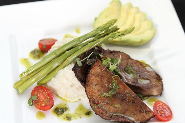 Steak with asparagus and whipped potatoes plated with avocado