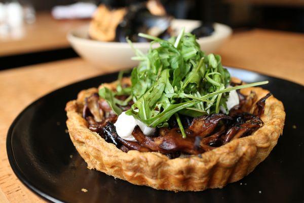 Foraged Mushroom Tart. Arugula stacked on top of mushrooms and balls of goat cheese.