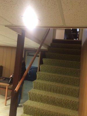 "Before" photo of stairs of a basement room remodel.