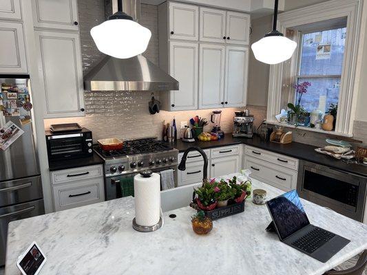 Perimeter counters is black pearl in a leather finish. Island w farmhouse sink is also granite. Window sill matches the island.