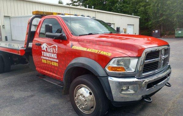 White tow truck wrapped red with reflective logos