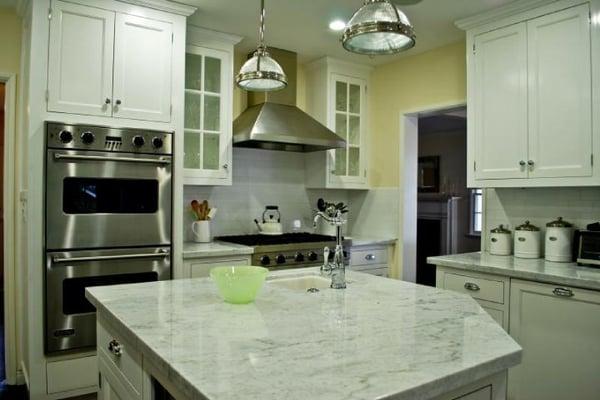 White Carrara counter tops with a white subway tile back splash.