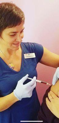 Dr. Korza administering a vitamin injection.