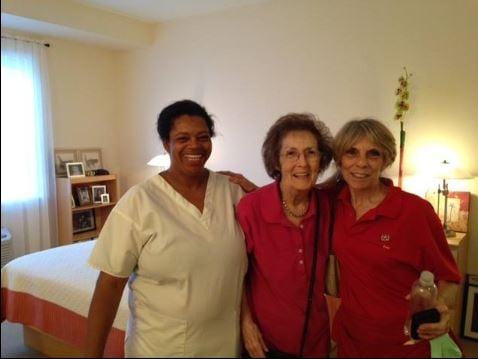 Staff member, right, proudly shows off the finished studio to client & her aide. Everyone wears smiles because of how beautiful it looks.