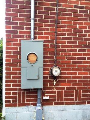 This is a work in progress picture, which shows the new electrical meter with a main breaker compared to the old meter on the right.