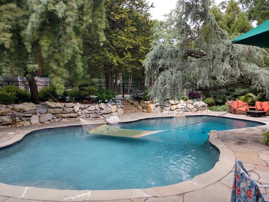 Natural Look pool with Moss Rock retianing wall, natural blue stone coping and patio