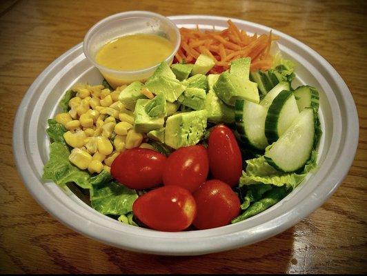 Jaddi's salad. Romaine lettuce, cherry tomatoes, sliced cucumbers, corn, shredded carrots, housemade orange vinaigrette