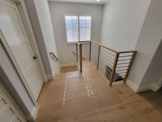 We installed railing and cap in this house. White oak post and railing system with stainless steel horizontal rods.