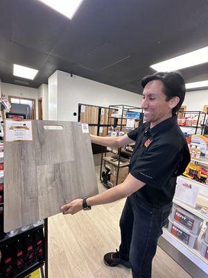 Juan holding up flooring sample