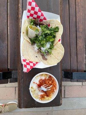 Street tacos $7 and corn in a cup $4.