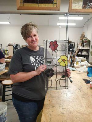 A student from the Leaded Window class displays her finished panel