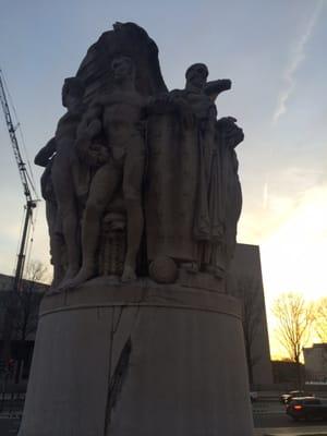 On the back side of the statue an ominous man portrays war.