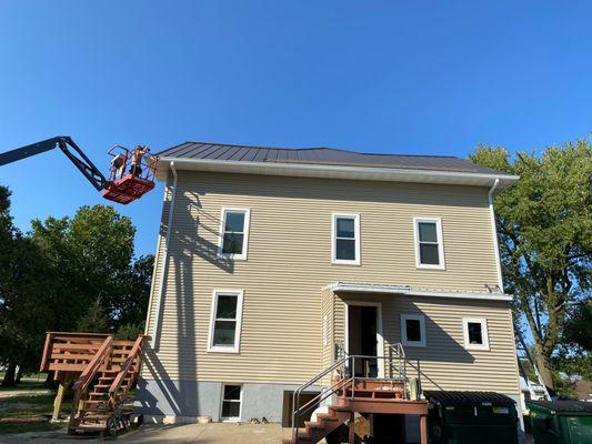 Installing six inch gutters and downspouts on Megan Hall, Divine Word College Epworth IA