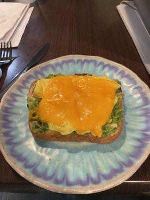 Avocado toast with a scrambled egg and sharp cheddar cheese! Yum