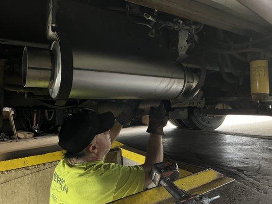 This is the owner of the business working out how much welding and adapting would be necessary to attach the new muffler and tailpipe.