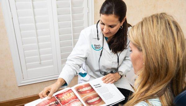 Dr. Caitilin Martini shows a patient what's possible with porcelain veneers