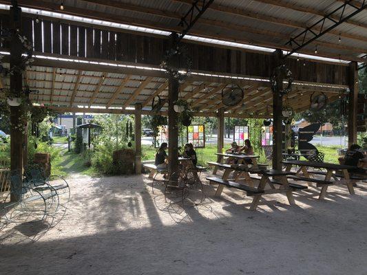 Shaded seating area next to the green with fans and plants