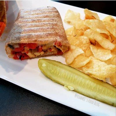 Philly Cheesesteak Wrap with chips and a pickle.